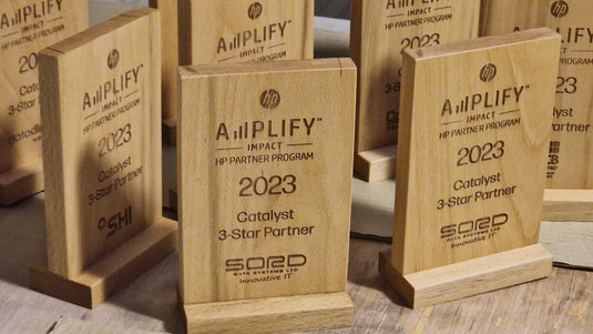 Custom Wood Designs custom-made awards with engraved plaques, displayed on a wooden shelf, highlighting craftsmanship and quality.