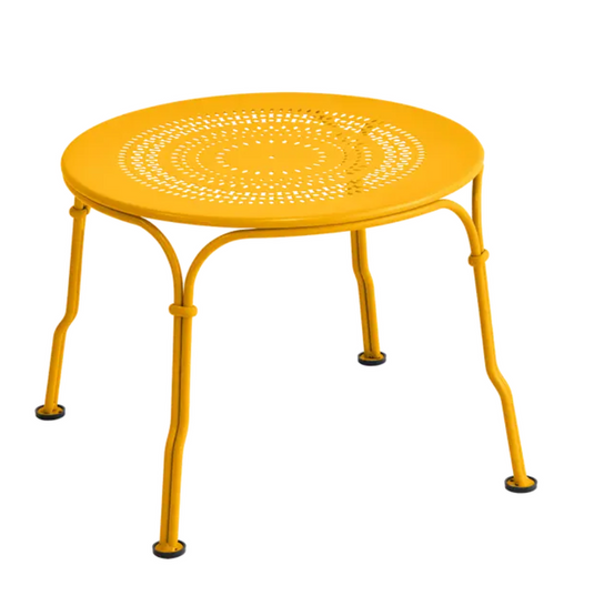 Fermob 1900 low table with a 45 cm diameter, honey-colored metal surface and sleek round design for indoor or outdoor use.