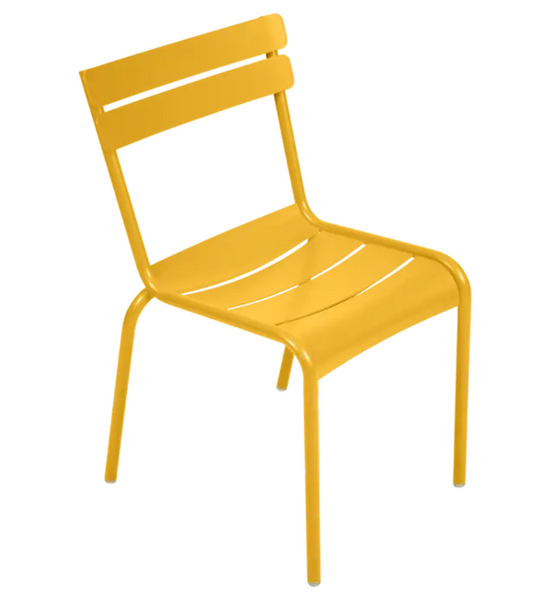 Fermob Luxembourg armchair in honey yellow with a metal frame, stackable design, suitable for outdoor or restaurant use.