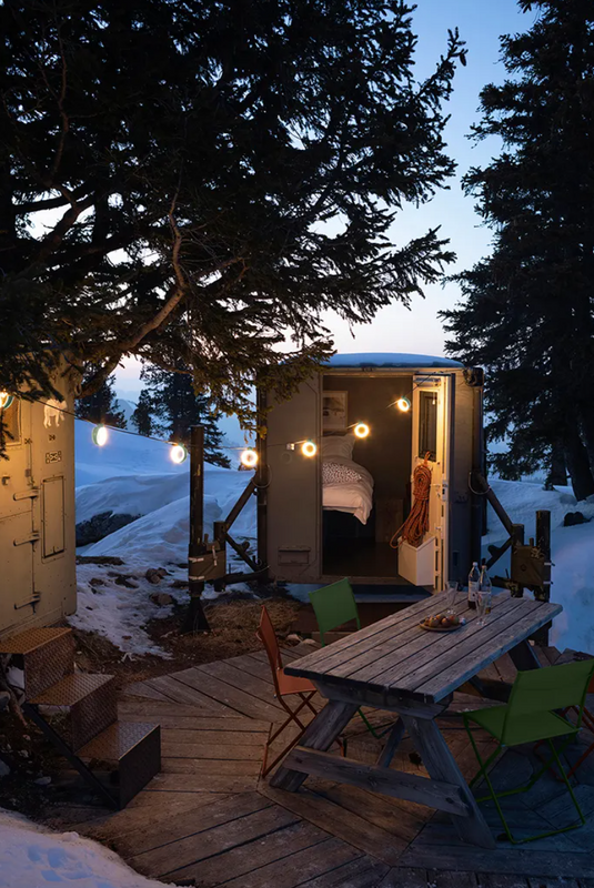 Fermob HOOPIK outdoor string lights hanging above an outdoor restaurant setting, providing ambient lighting.