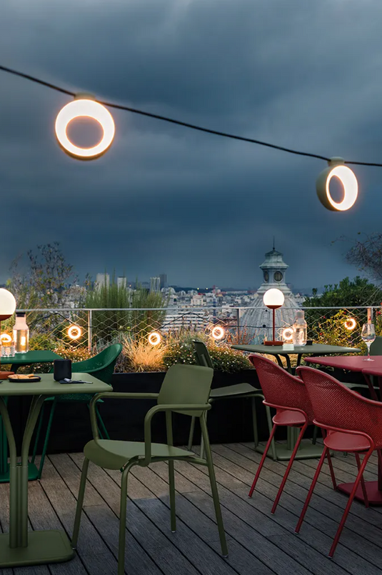 Fermob HOOPIK outdoor string lights L1200cm hanging above a patio for restaurant or hotel outdoor ambiance.