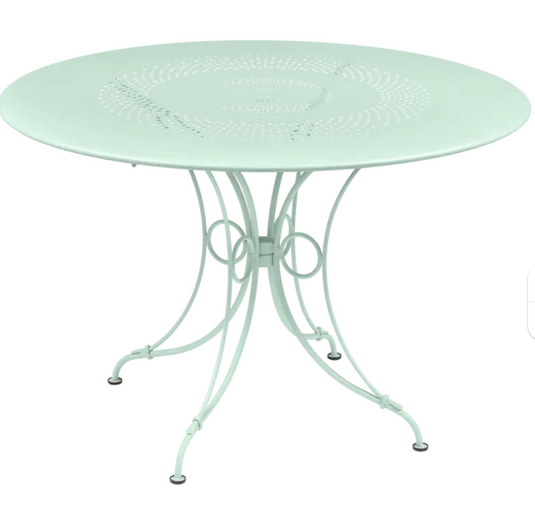 Ice Mint Fermob 1900 outdoor round table with 117 cm diameter, featuring a sleek metal design for outdoor dining.