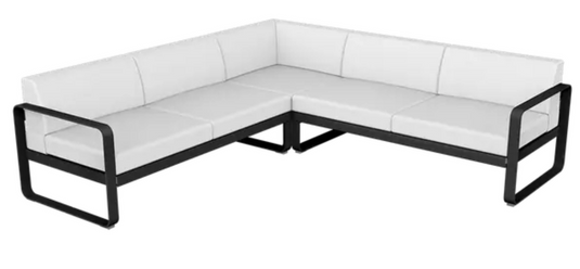 Fermob Bellevie Composition 2 outdoor lounge set with white modular sofas and liquorice-colored cushions on a patio.