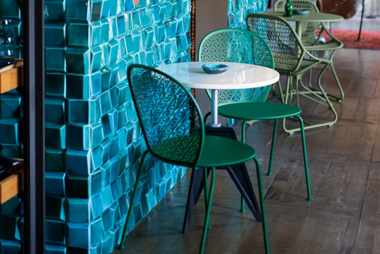 Colorful Fermob Lorette outdoor metal chair with a sleek design, suitable for garden or patio seating.