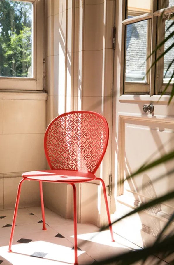 Fermob Lorette outdoor metal chair with a curved backrest, suitable for restaurant and outdoor living settings.