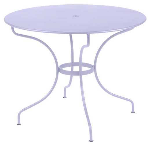 Fermob OPÉRA+ outdoor metal table with a 96 cm diameter, designed for five seating, in a stylish outdoor patio setting.