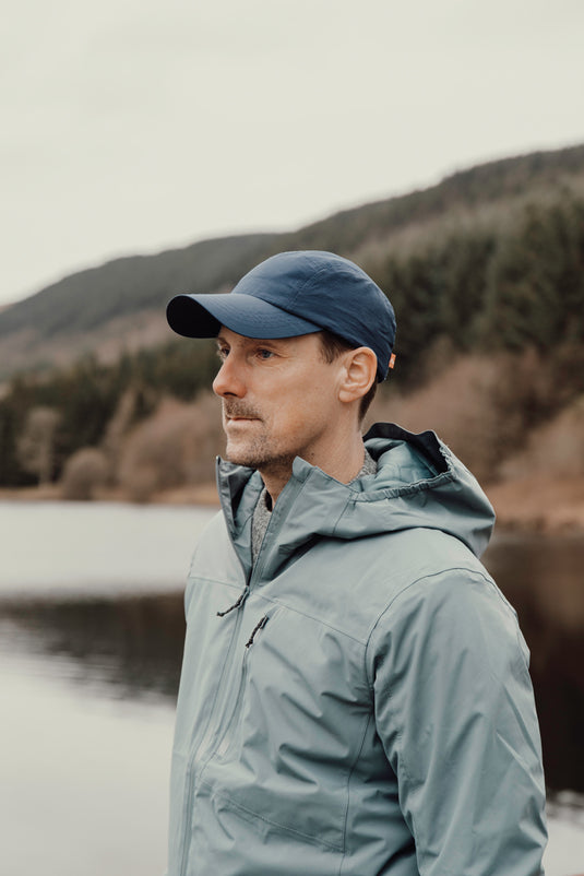 Nordic Drift RCS Aero UPF 50+ cap in black with curved brim and adjustable strap, designed for sun protection and sporty style.
