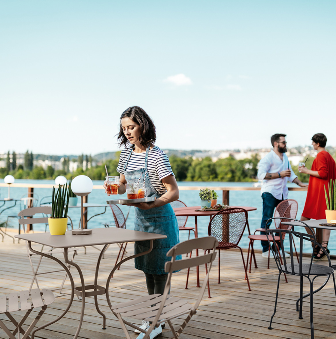 Fermob LA MÔME Chai folding chair in vibrant orange, lightweight metal design, perfect for outdoor seating and easy portability.