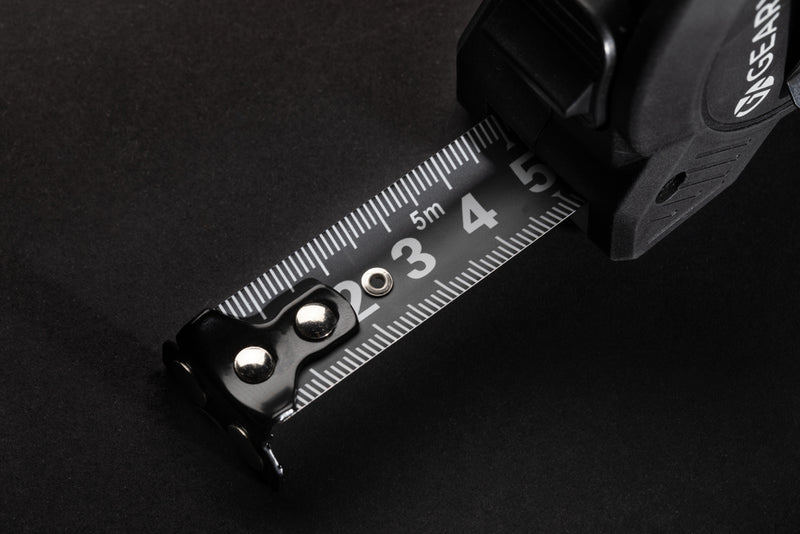 Load image into Gallery viewer, Gear X 5M measuring tape with slow/fast retract function, durable tools and torches, close-up of tape retraction mechanism.
