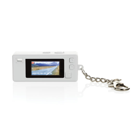 XD Xclusive Cliq it RCS recycled keychain camera attached to a phone, showcasing its compact design and eco-friendly material.