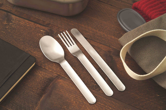 Black + Blum outdoor cutlery set with stainless steel utensils and black handles, ideal for camping or outdoor dining.