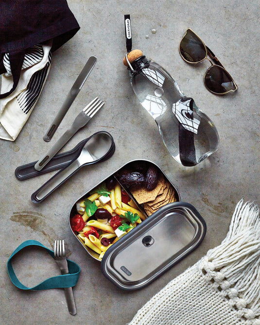 Black + Blum outdoor cutlery set with black handles, including fork, knife, and spoon, designed for portable outdoor dining.