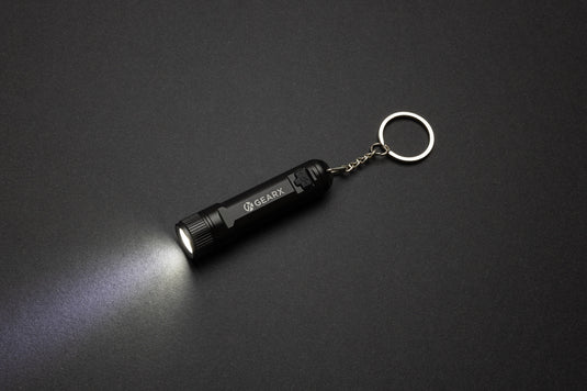 GearX rechargeable ultra bright keychain torch showing compact design with bright LED light and keyring attachment.