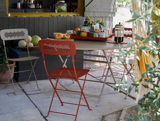 Fermob Caractère foldable metal table with 128 cm diameter, designed as an eight-seater for outdoor or indoor use.