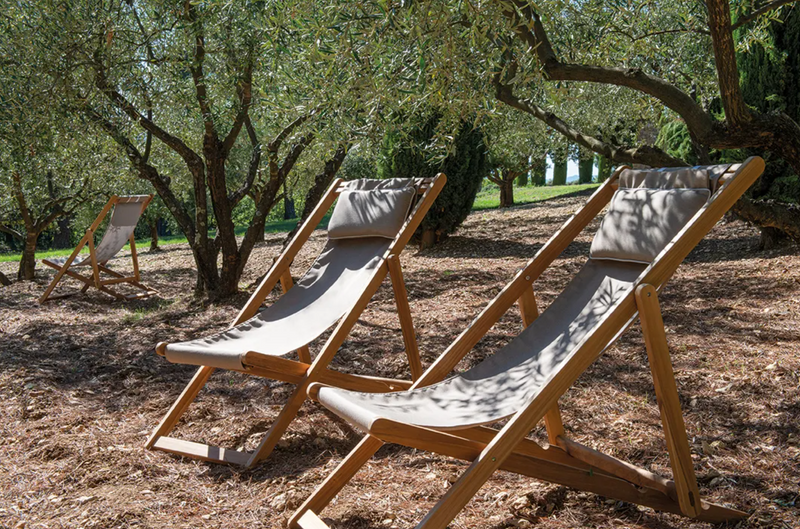 Load image into Gallery viewer, Fermob IBIZA teak deckchair with a natural wood finish, featuring a slatted design and sturdy armrests for outdoor lounging.
