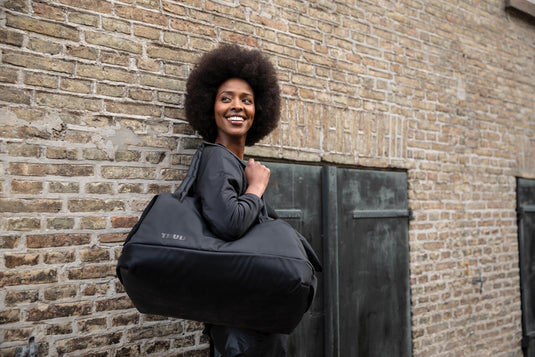Thule Subterra 2 35L duffel bag in black, showing durable fabric, sturdy handles, and spacious design for travel storage.