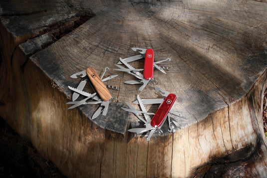 Victorinox Huntsman Wood pocket knife with 13 functions, open tools including blades, screwdrivers, and scissors on a wooden handle.