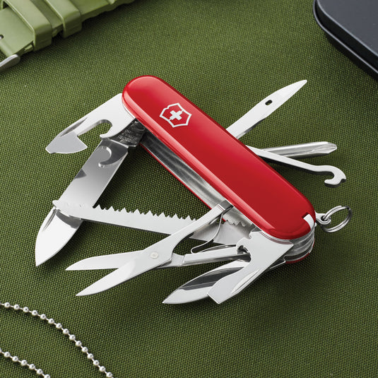 Victorinox Swiss Army Fieldmaster pocket knife with 15 functions, featuring blades, screwdrivers, and scissors, open on a wooden surface.