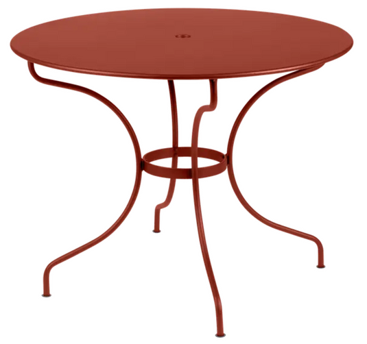 Red Ochre Fermob OPÉRA+ outdoor metal table with 96 cm diameter, suitable for five-seater patio seating.