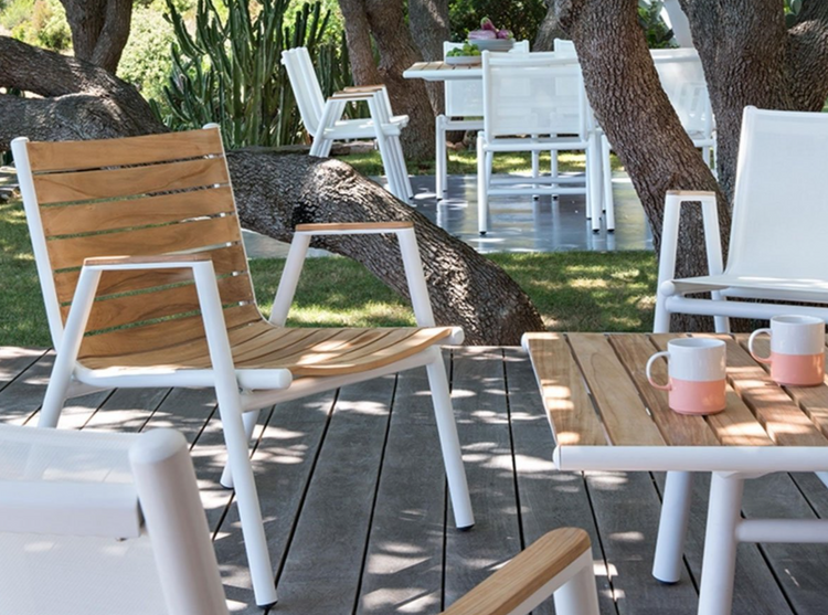 Red ochre Fermob Pilotis teak outdoor armchair with low arms, showcasing solid teak construction and modern design.