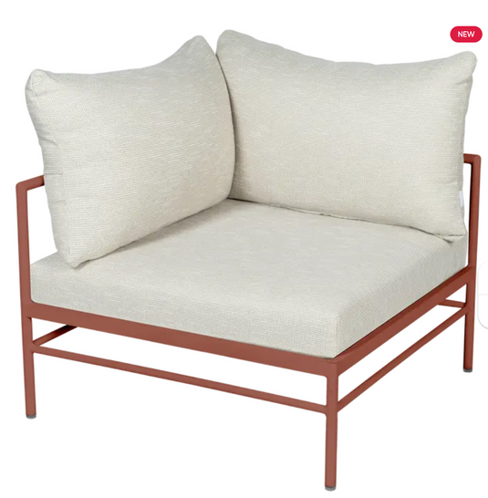 Red metal Rivage corner armchair from Fermob with wicker detailing, part of the outdoor corner sofa collection.