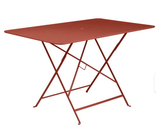 Red Fermob foldable bistro table with 117x77 cm outdoor metal design, perfect for compact outdoor dining and patio use.