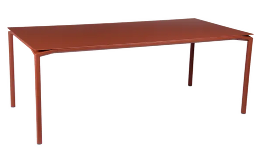 Red Fermob CALVI rectangular outdoor dining table, 195 x 95 cm, eight-seater, suitable for indoor or outdoor use.