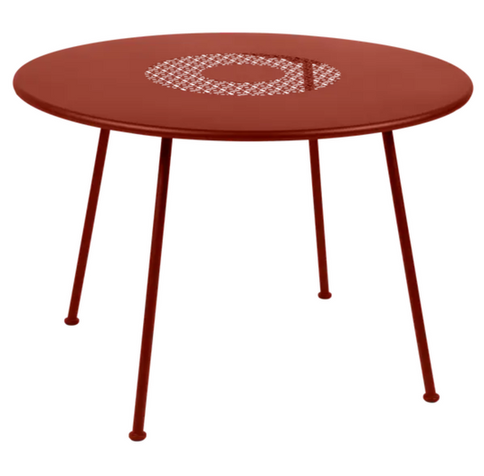 Red ochre Fermob Lorette round garden table with 110 cm diameter, metal fire-resistant outdoor furniture for garden seating.