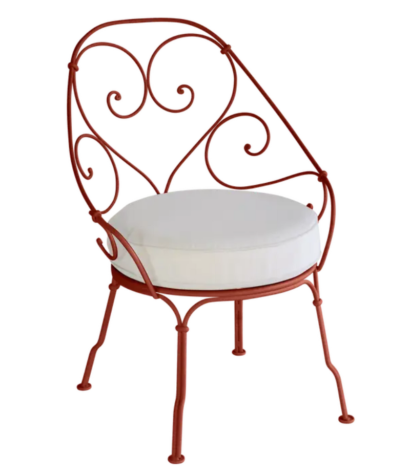 Load image into Gallery viewer, Red Ochre Fermob Cabriolet outdoor armchair with off-white cushions, metal frame, stylish and comfortable for outdoor seating.
