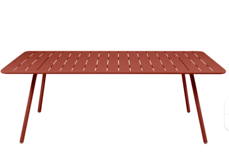 Load image into Gallery viewer, Red ochre Fermob Luxembourg outdoor table, 210 x 100 cm, sturdy outdoor furniture for patio or garden spaces.
