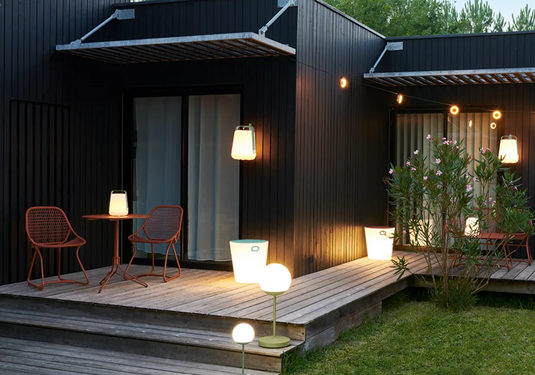 Red woven Fermob Sixties Low Armchair with low arms, stylish lounge chair suitable for outdoor or restaurant use.