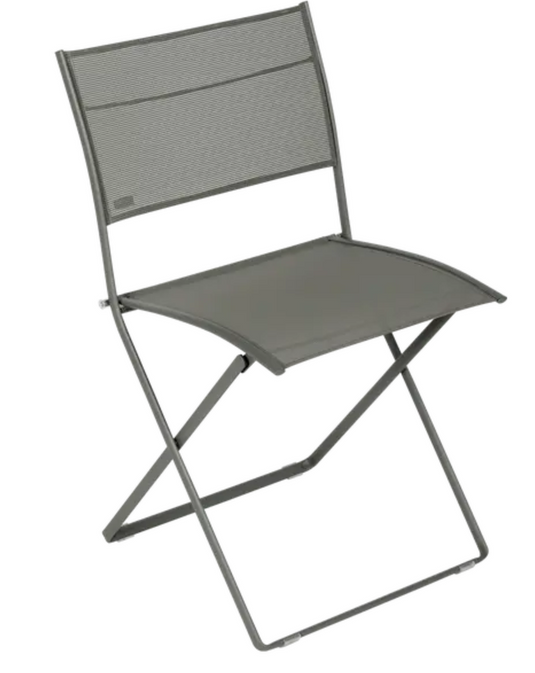 Fermob Plein Air folding chair in outdoor setting, featuring a lightweight design and colorful fabric seat for comfortable relaxation.