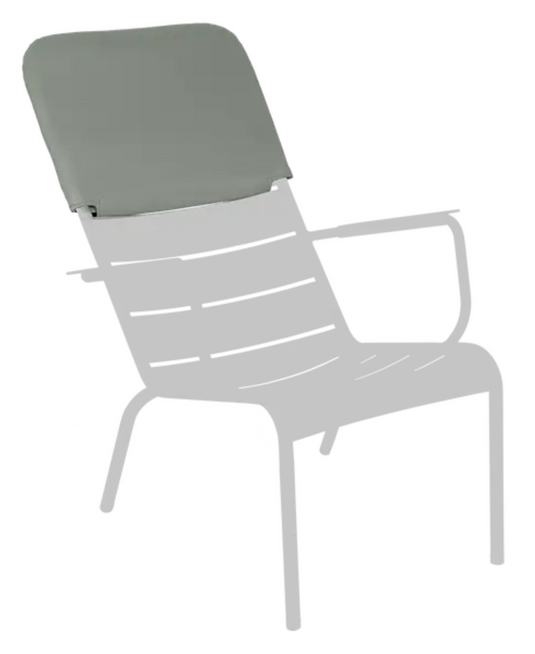Fermob Luxembourg low armchair headrest with adjustable fabric cushion in a natural outdoor setting.
