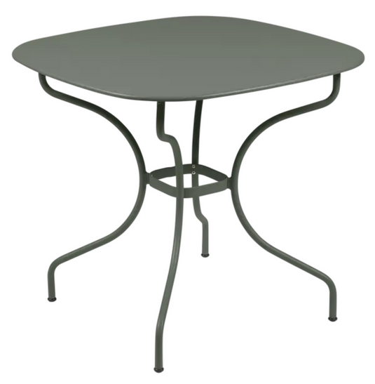 Fermob OPÉRA+ Carronde outdoor metal table, 82x82 cm, shown in a garden setting with a modern design and smooth surface.