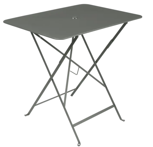 Fermob foldable bistro table in metal with 77x57 cm size, suitable for outdoor use, shown in a natural outdoor setting