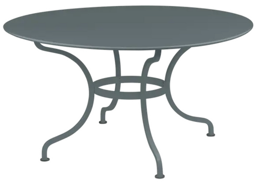 Storm Grey Fermob Romane round table with 137cm diameter, seating up to 8 guests, outdoor furniture for dining and gatherings.