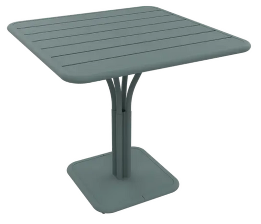 Luxembourg Fermob outdoor pedestal table in storm grey with 80x80 cm square tabletop, suitable for garden or patio use.