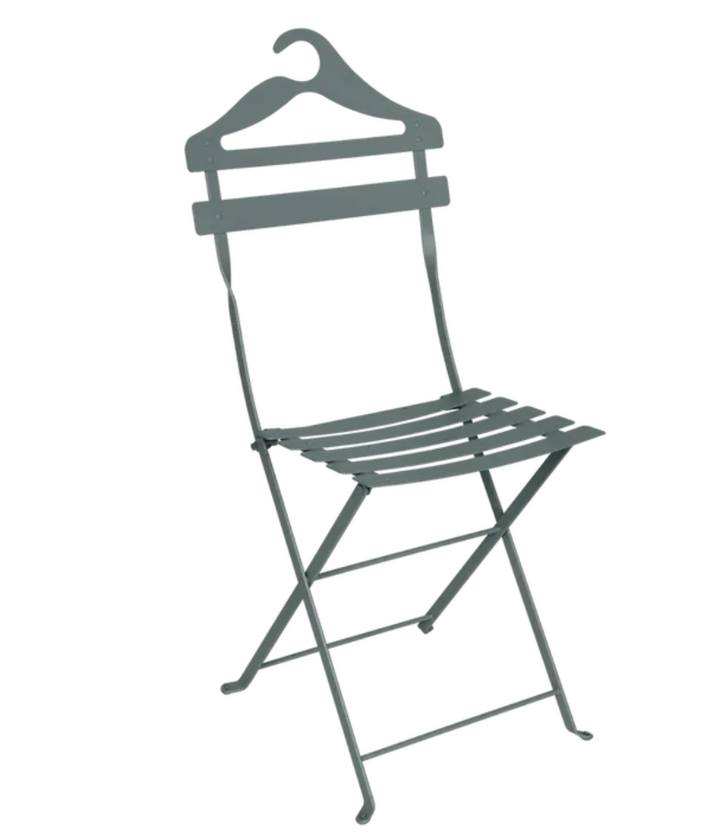 Load image into Gallery viewer, Storm grey Fermob Bistro Valet Folding Chair made of metal, shown hanging in a natural setting.
