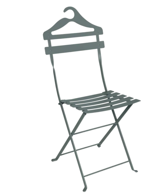 Storm grey Fermob Bistro Valet Folding Chair made of metal, shown hanging in a natural setting.