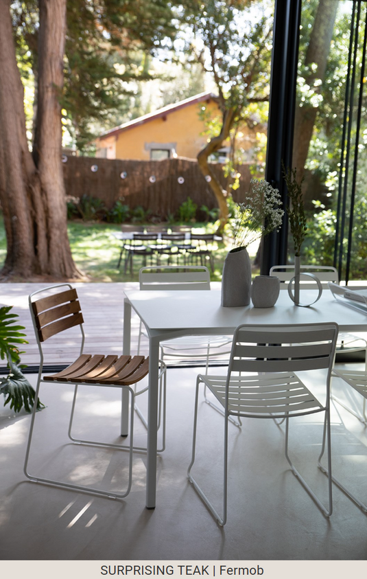 Fermob Surprising Teak Chair, outdoor metal chair with teak accents, shown in an outdoor setting with a modern design.