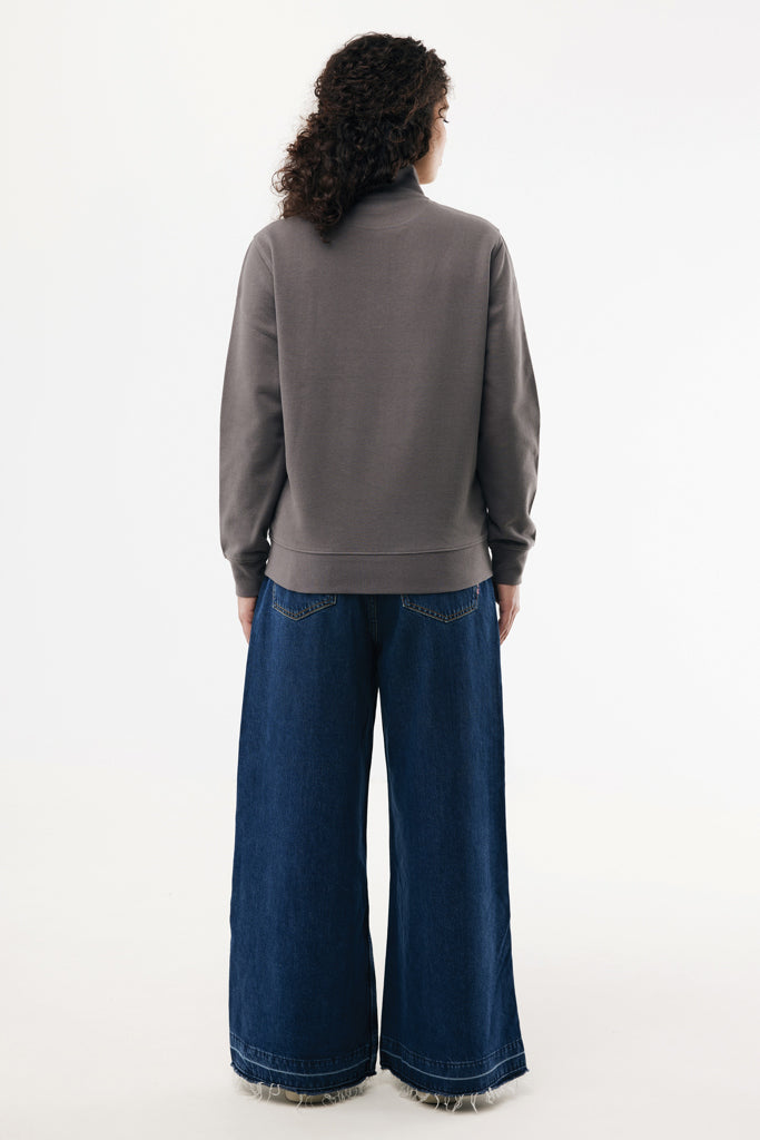 Load image into Gallery viewer, Iqoniq Elgon recycled cotton quarter zip sweater, close-up showing fabric texture and zipper detail in a natural textile setting.
