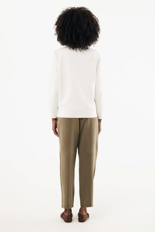 Iqoniq Elgon recycled cotton quarter-zip sweater, close-up of green textile with zipper and textured fabric.