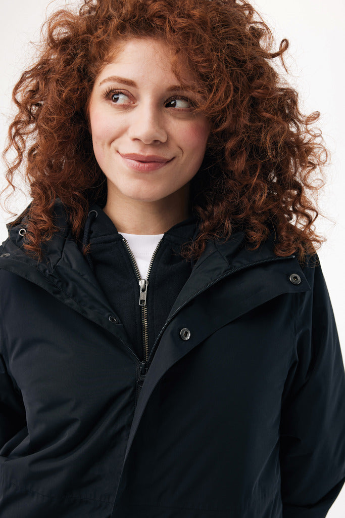 Load image into Gallery viewer, Iqoniq Thelon recycled polyester parka in textile, shown with front view, featuring a hood and button closure for casual winter wear.
