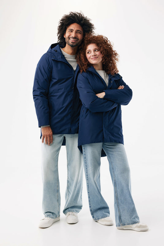 Iqoniq Thelon recycled polyester parka, textile outerwear with hood and zipper, shown in a natural outdoor setting.