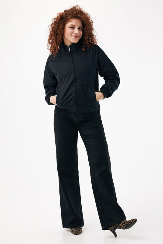Iqoniq Odin recycled polyester urban jacket hanging on a wooden hanger, showcasing its modern design and eco-friendly fabric.
