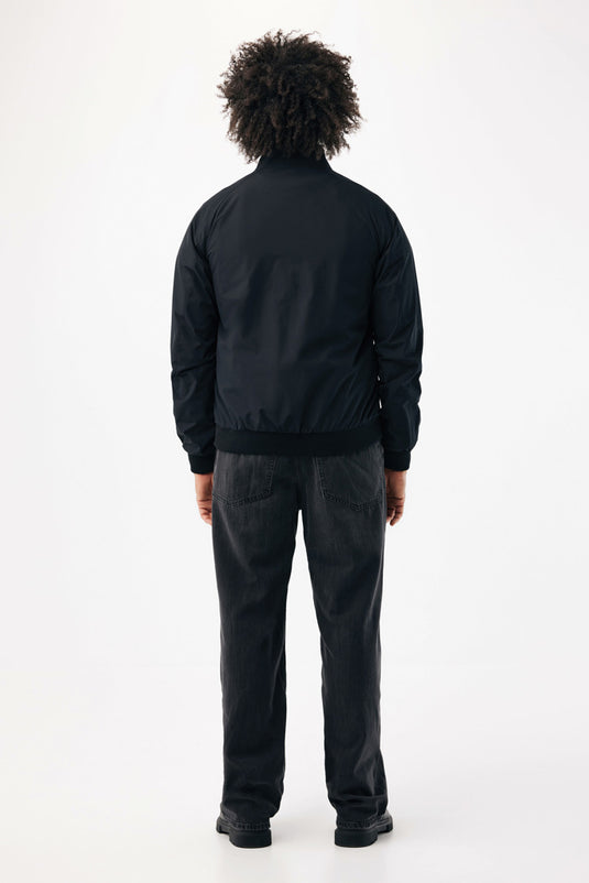 Iqoniq Odin recycled polyester urban jacket textile in black, showing the jacket's front view with hood and zipper closure.