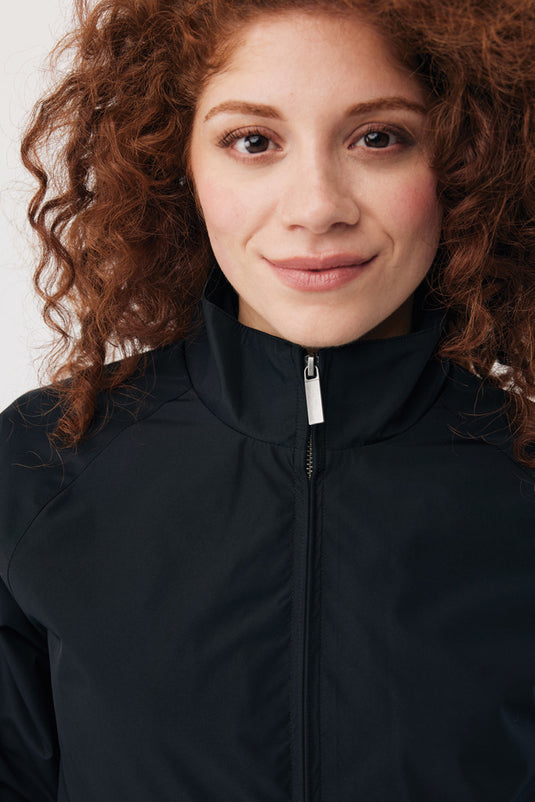 iqoniq Odin recycled polyester urban jacket, close-up view showing black textile fabric and sleek design details.