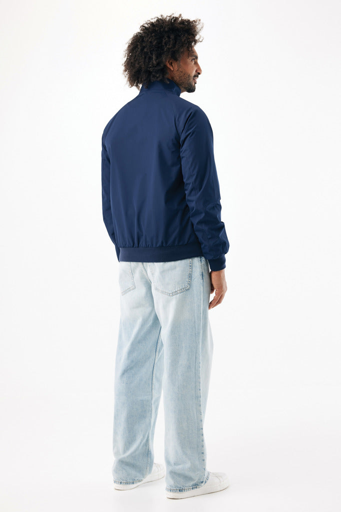 Load image into Gallery viewer, Iqoniq Odin recycled polyester urban jacket lying flat, showcasing its sleek textile design and sustainable fabric.
