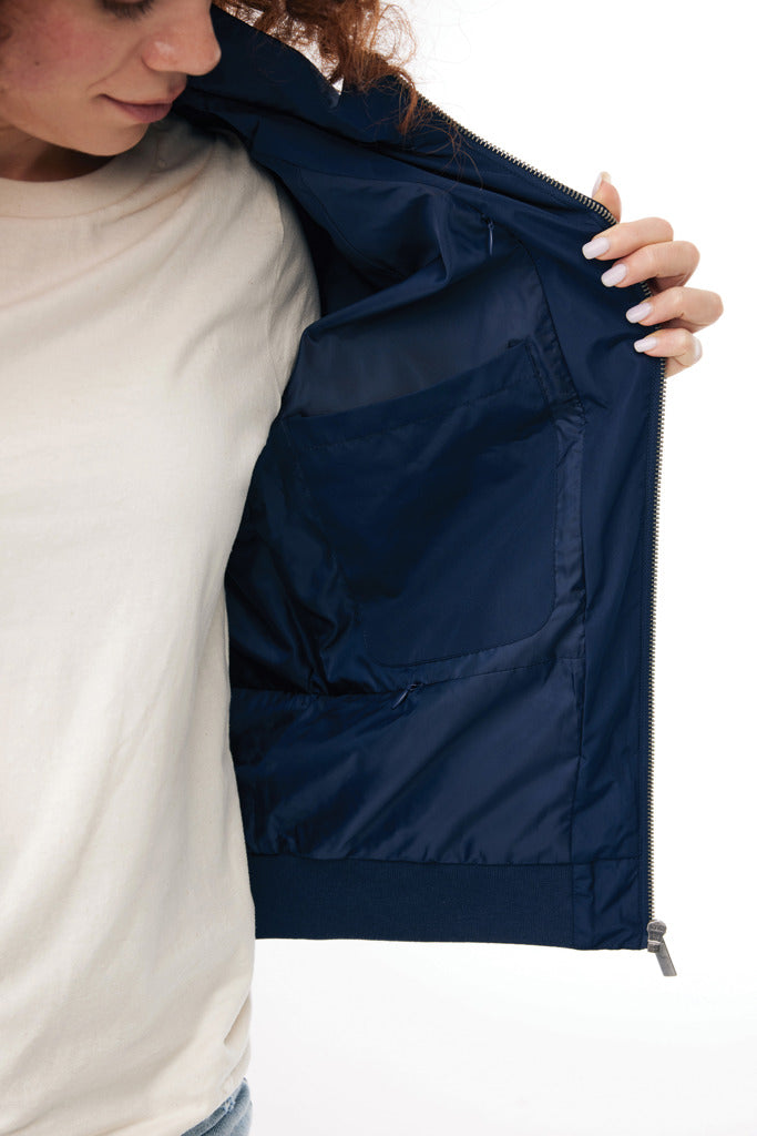 Load image into Gallery viewer, Iqoniq Odin recycled polyester urban jacket hanging on a hanger, showcasing its textile fabric and modern design.

