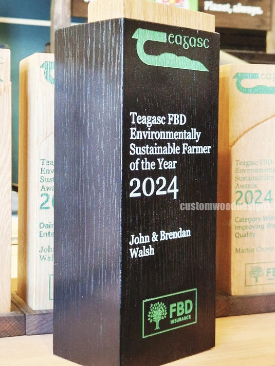 Custom wood awards from Custom Wood Designs for environmental sustainability, featuring engraved designs on polished wooden plaques.